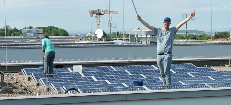 Mitglieder der Energiegenossenschaft Erfurt reinigen die Solarmodule auf dem LKA in Erfurt